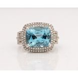 An 18ct white gold, aquamarine and diamond cluster ring, claw set with the cushion cut...