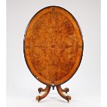 A Victorian marquetry inlaid figured walnut snap top oval centre table, on four downswept...