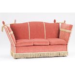 A pink upholstered hump back Knole sofa with tassel fringe, 195cm wide x 108cm high.