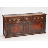 A George III pine dresser base, with three drawers over a pair of cupboards, 184cm wide x 88cm...