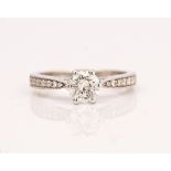 An 18ct white gold and diamond ring, claw set with the circular cut diamond between circular...