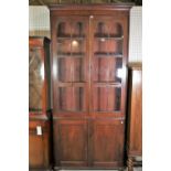 A late William IV mahogany bookcase cabinet with arched glazed doors over cupboard base