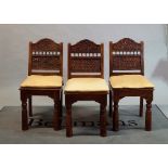 A set of eight Indian hardwood dining chairs with floral trellis carved back on turned supports,