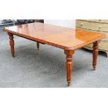 A Victorian style mahogany extending dining table, on reeded baluster supports, with one extra...