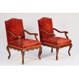 A pair of 19th century French walnut framed open armchairs with shaped frieze on cabriole...
