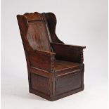 An 18th century oak lambing chair with lift box seat, 67cm wide x 112cm high.