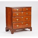 A mid-18th century oak chest with two short and three long graduated drawers on bracket feet,...