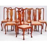 A set of eight Queen Anne revival stained beech vase back dining chairs on cabriole supports,...