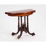 A Victorian figured walnut card table of serpentine outline on turned columns and four down...