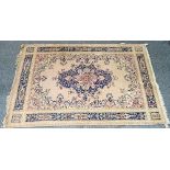 A Konya carpet, Turkish, the pale pink field with a dark indigo medallion, and outer surround,...