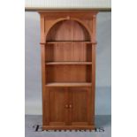 A modern pine floor standing open bookcase with three shelves over a pair of cupboards