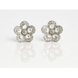 A Tiffany & Co pair of platinum and diamond earstuds, each designed as a flowerhead, mounted...