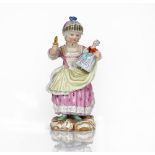 A Meissen figure of a girl, late 19th century, standing holding a doll and rattle, blue...
