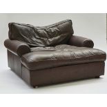 An oversized brown leather upholstered easy armchair