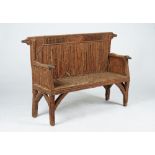 A rustic style settle with hounds' head terminals