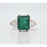 An 18ct white gold, emerald and diamond set dress ring