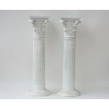 A pair of white glazed pottery columns