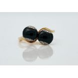 A gold, black onyx and diamond ring