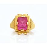 A gold and synthetic ruby single stone ring