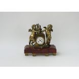 A French gilt-metal and rouge marble mantel clock