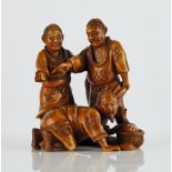 A Japanese stained ivory netsuke of three fishermen