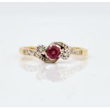 A gold, ruby and diamond three stone ring