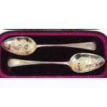 Two similarly decorated silver dessert serving spoons (2)