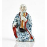 A CHINESE PORCELAIN FIGURE OF A LUOHAN