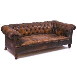 AN EARLY 20TH CENTURY BROWN LEATHER UPHOLSERED CHESTERFIELD SOFA
