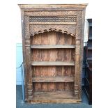 AN EXTENSIVELY CARVED INDIAN HARDWOOD OPEN BOOKCASE