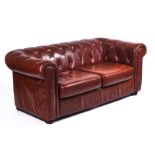 A 20TH CENTURY BROWN LEATHER UPHOLSTERED CHESTERFIELD SOFA