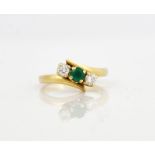 AN 18CT GOLD, EMERALD AND DIAMOND THREE STONE RING