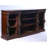 A VICTORIAN CARVED OAK BREAKFRONT FLOOR STANDING OPEN BOOKCASE