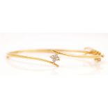 A GOLD AND DIAMOND SET OVAL HINGED BANGLE