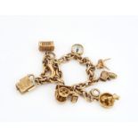 A 9CT GOLD CHARM BRACELET