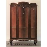 An early 20th century mahogany serpentine display cabinet