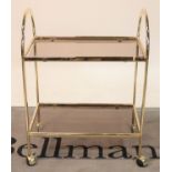 A modern brass and glass two tier serving trolley