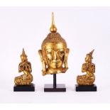 A SOUTH-EAST ASIAN GILT HEAD OF A BUDDHA TOGETHER WITH A PAIR OF KNEELING FIGURES (3)