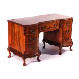 A MID-20TH CENTURY FIGURED WALNUT KNEEHOLE WRITING DESK