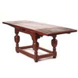 A 17TH CENTURY STYLE OAK DRAW LEAF EXTENDING DINING TABLE