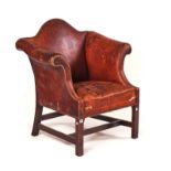 A GEORGE II STYLE TAN LEATHER UPHOLSTERED LOW HUMP BACK ARMCHAIR