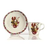 A NYMPHENBURG HAUSMALER ARMORIAL COFFEE CUP AND SAUCER