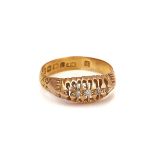 A GOLD RING MOUNTED WITH A ROW OF FOUR SMALL GRADUATED DIAMONDS