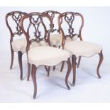A SET OF FOUR VICTORIAN CARVED WALNUT FRAMED BALOON BACKED DINING CHAIRS