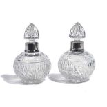 A PAIR OF SILVER MOUNTED FACETED GLASS SCENT BOTTLES AND STOPPERS (2)