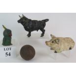 An antique cast iron pig money box with glass eyes, a painted alloy parrot money box,