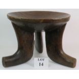 A large ethnic chip carved hardwood bowl raised on three splayed legs, probably of African origin.