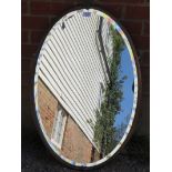 A vintage oval bevelled wall mirror with