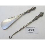 A silver handled button hook and shoe ho