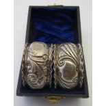 A pair of silver napkin rings heavily em
